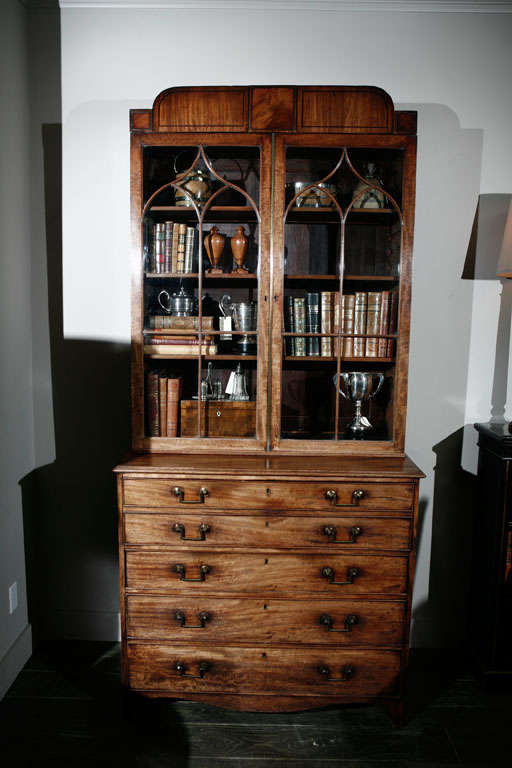 1840s English mahogany secretary bookcase. This handsome secretary has a unique raised cornice with rounded edges above arched muntin pattern glass doors and a secretary fall-front drawer enclosing small drawers and pigeon holes. The lower body