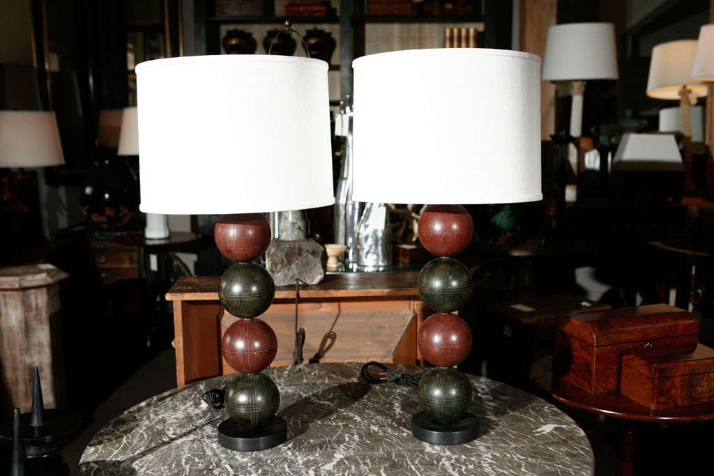 Playful lamps of stacked bocce balls in oxblood red and black. Fitted with custom shades