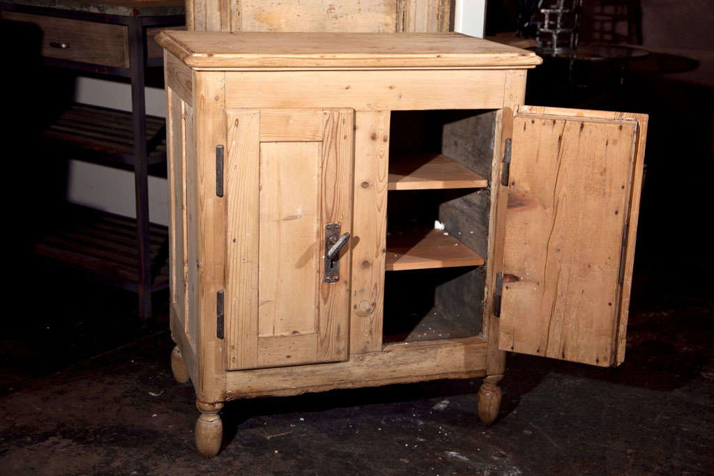 European pine ice box, late 19th century, in natural pine finish with iron door handles, ogee edge molded top, tul;ip shaped bun feet, tin lined interior, and custom wine rack built into one side.