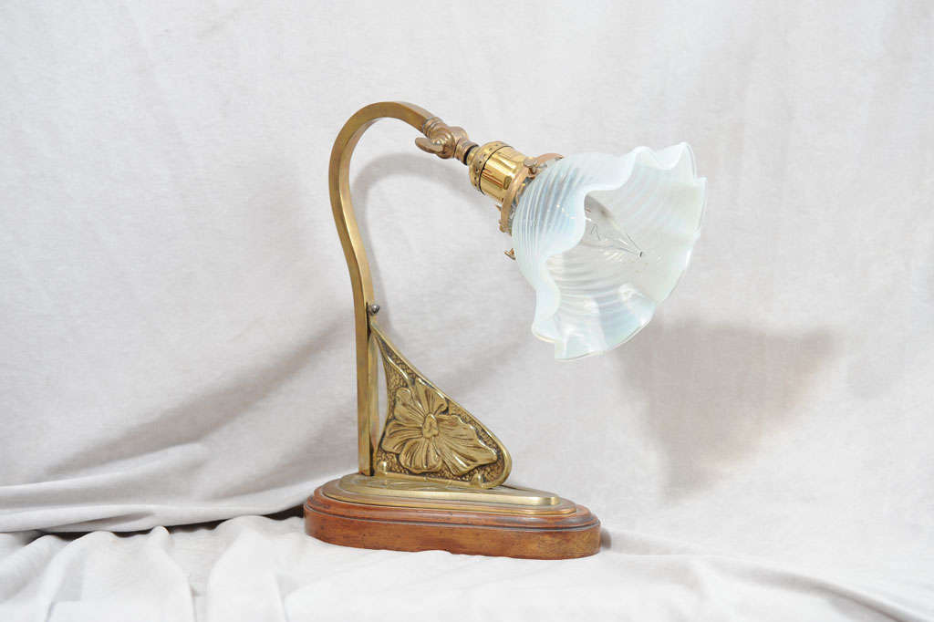 This lovely little desk lamp has all the elements that make art nouveau so enticing.  The beautiful metal work is mounted on the original wooden base and there is a loop in the back of the base so it can actually be hung on the wall and used as a