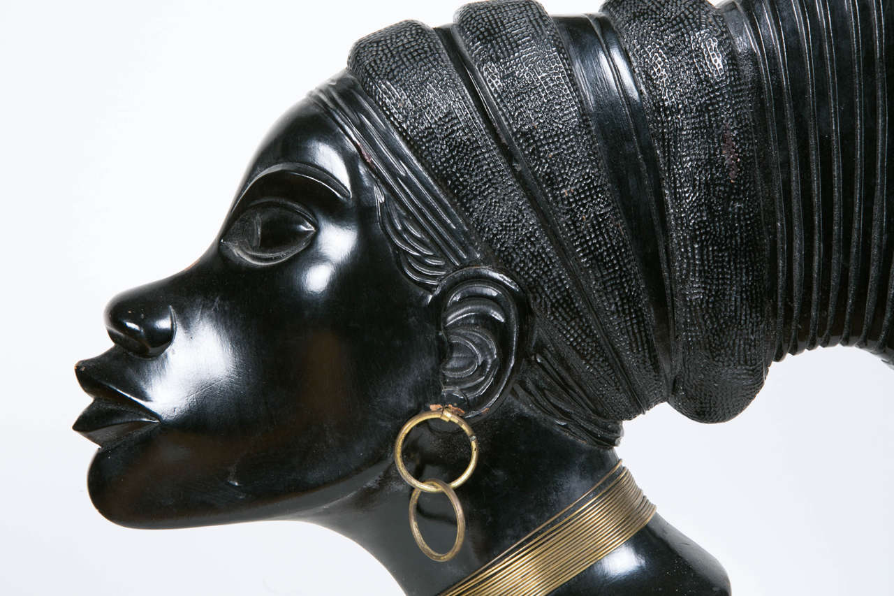 Profile of a woman. Africanist school. French work, circa 1930. 
Ebonized wood on a wooden base and copper wire jewelry. 

Note: A second sculpture of the same style is also available.