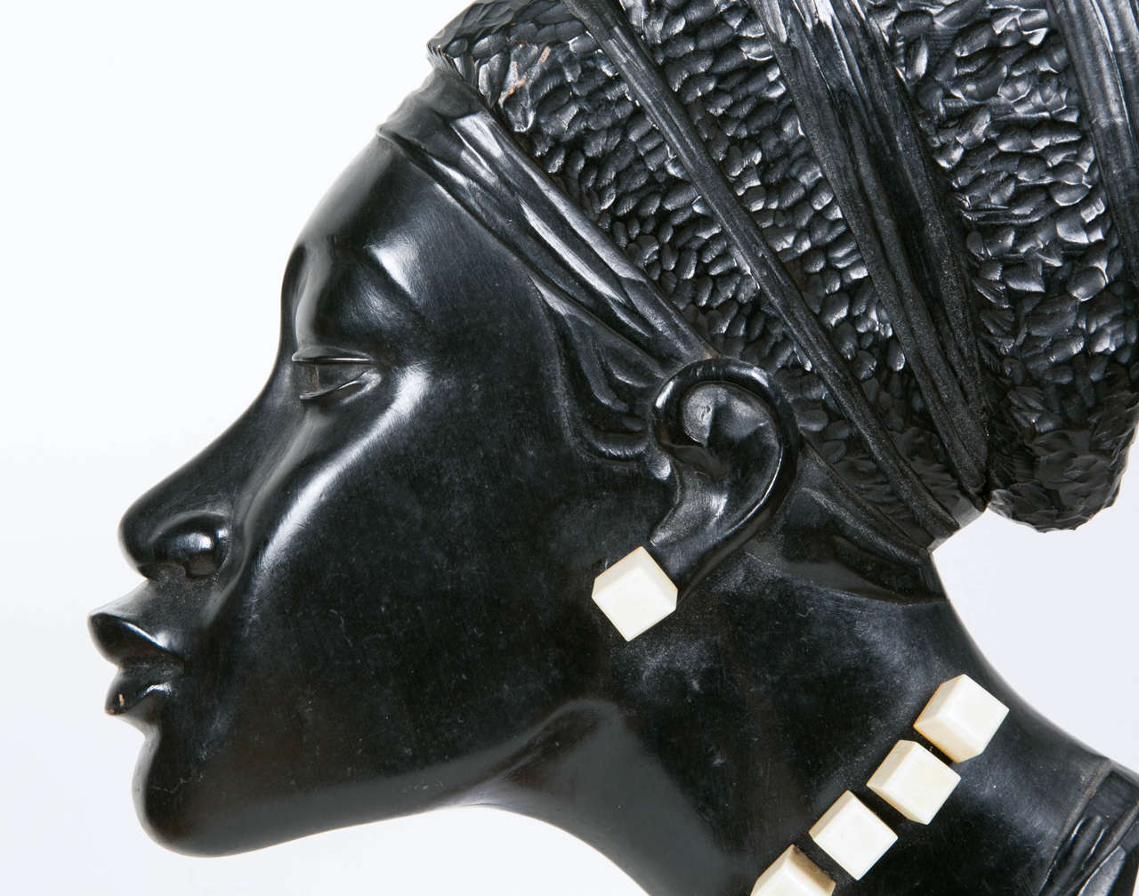 Profile of a woman. Africanist school. French work, circa 1930. 
Ebonized wood on a wooden base and white bakelite jewelry. 

Note: A second sculpture of the same style is also available.