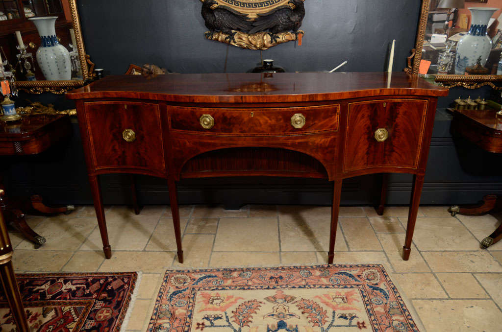 Unusual George III (Hepplewhite) mahogany crossbanded serpentine sideboard with tambour doors on square tapered legs and rare rosewood secondary woods.