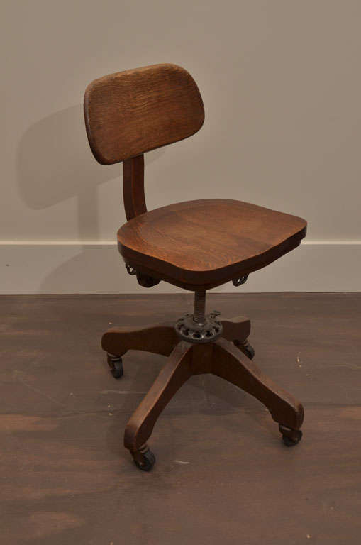 Vintage industrial oak desk chair, American, 20th century. 

Adjustable seatback, swivel base, and handsome industrial details. Star base sits on casters, making it easy to roll or move as needed. 

Seat height: 20-1/2