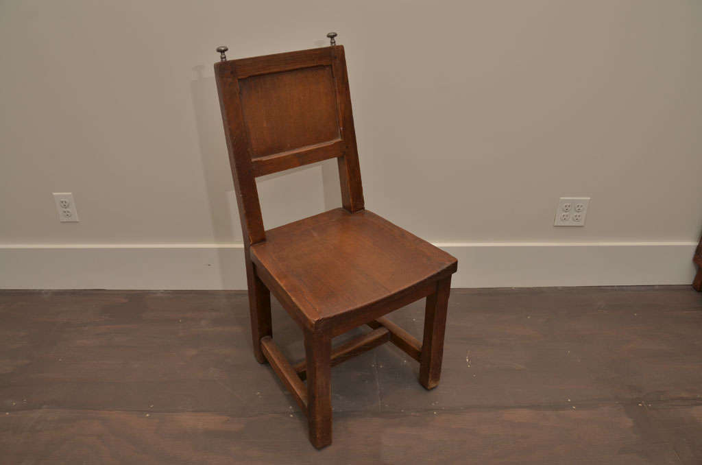 Set of 4 antique wood dining chairs with silver finials, France, circa 19th century. 

Simple construction consists of a sturdy frame, paneled backrest, and charming silver finials. Like many sets of the period, these chairs are both distinguished