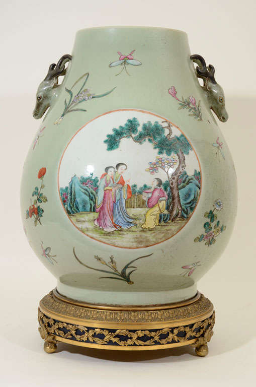 Large and Impressive Famille Rose Decorated Celadon Ground Hu Jar, with Deer Head Motif Handles, Mounted on a Gilt Bronze Base; the vase base with six character blue glaze pseudo Quianlong mark, China, 19th Century.<br />
<br />
Overall size: 21.5