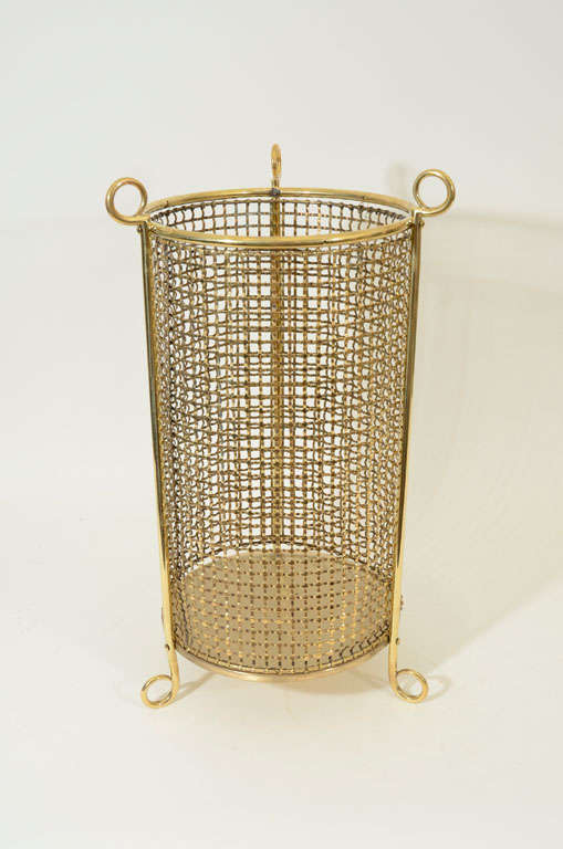 Tall, Round Polished Brass Mesh Waste Bin / Umbrella Stand Raised on Round Brass Feet.  England, Late 19th / Early 20th Century.<br />
<br />
21 inches high x 12 inches diameter