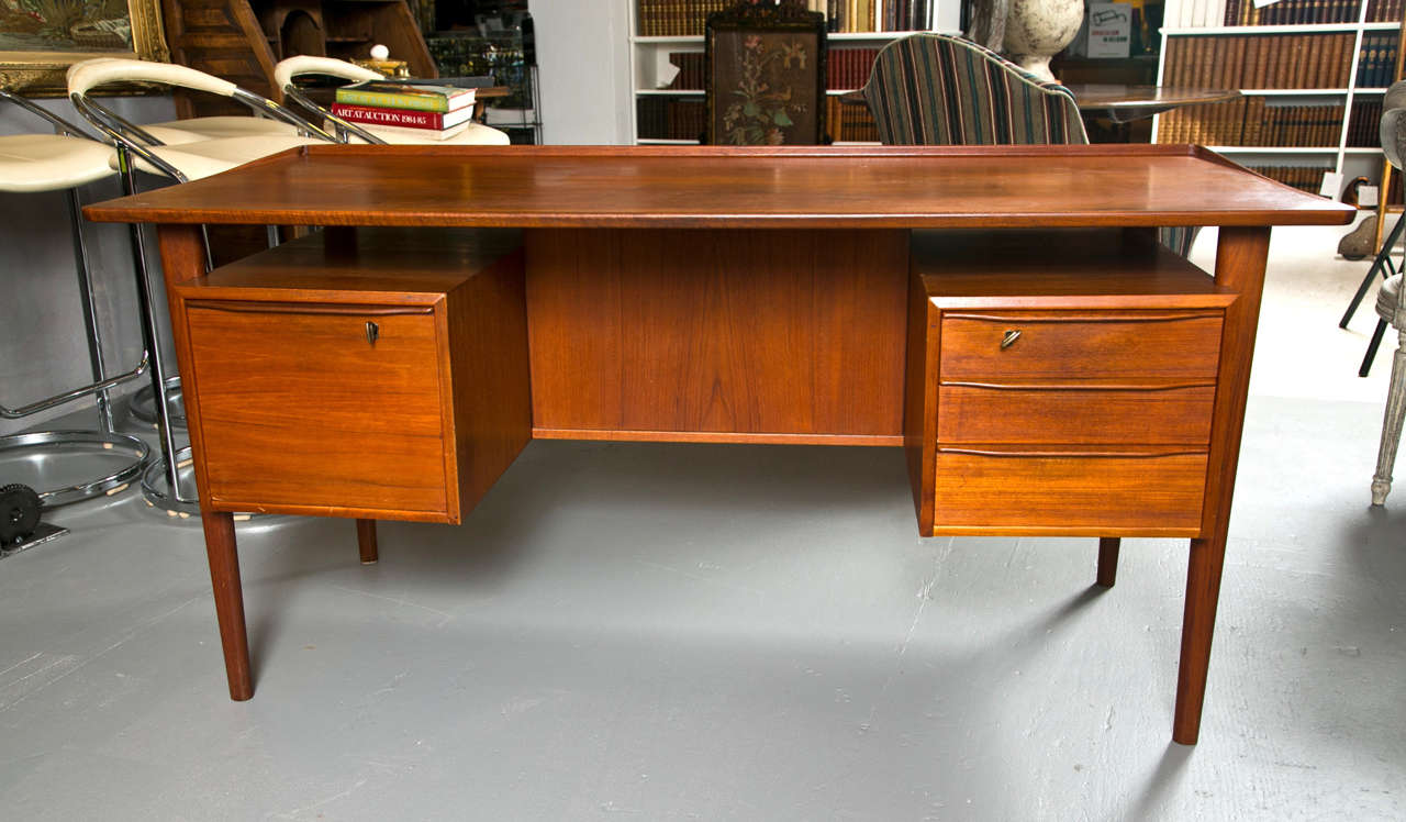 Luvig Dansk mid-century teak two sided desk

Back side - 1 sided book or display case

Front side left large file drawer
Front side right three small drawers

Some pen marking inside one drawer.

Signed 