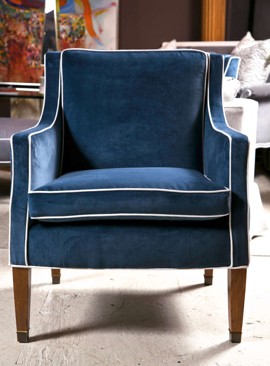 Mid-Century club chairs with blue velvet upholstery and white piping.