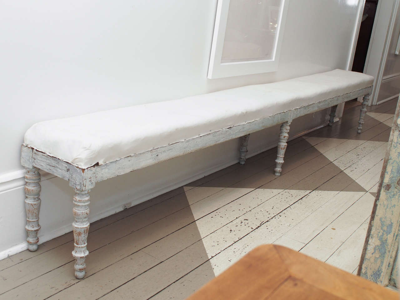 Pair of painted and upholstered benches.  These benches are 
beautifully simple.  Very long and narrow with nice detail on the wooden turned legs.
