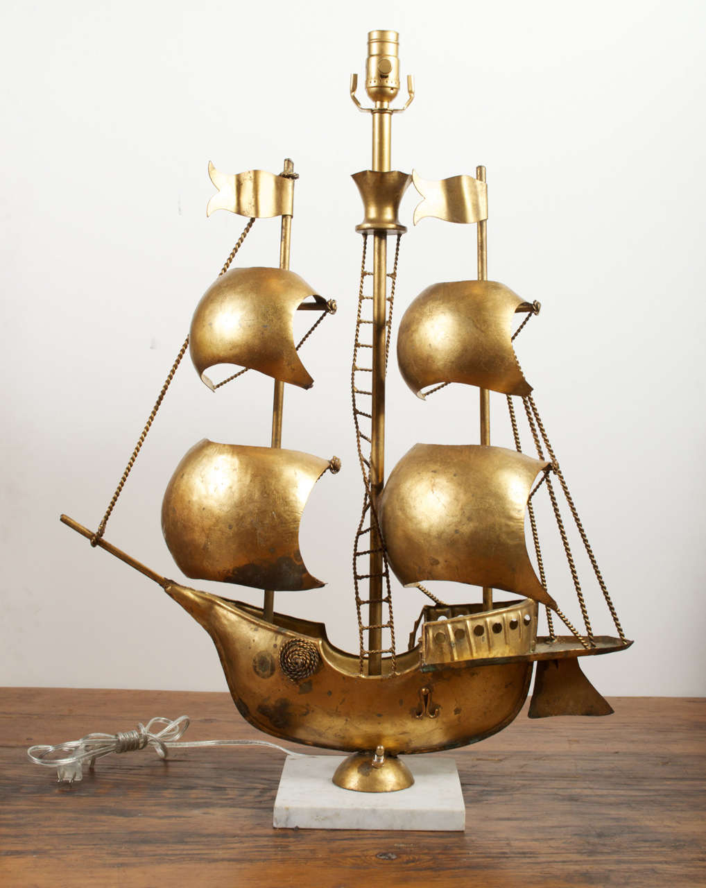 Painted metal pirate ship with white marble base. Single Edison socket and brass saddle to mount lamp shape.