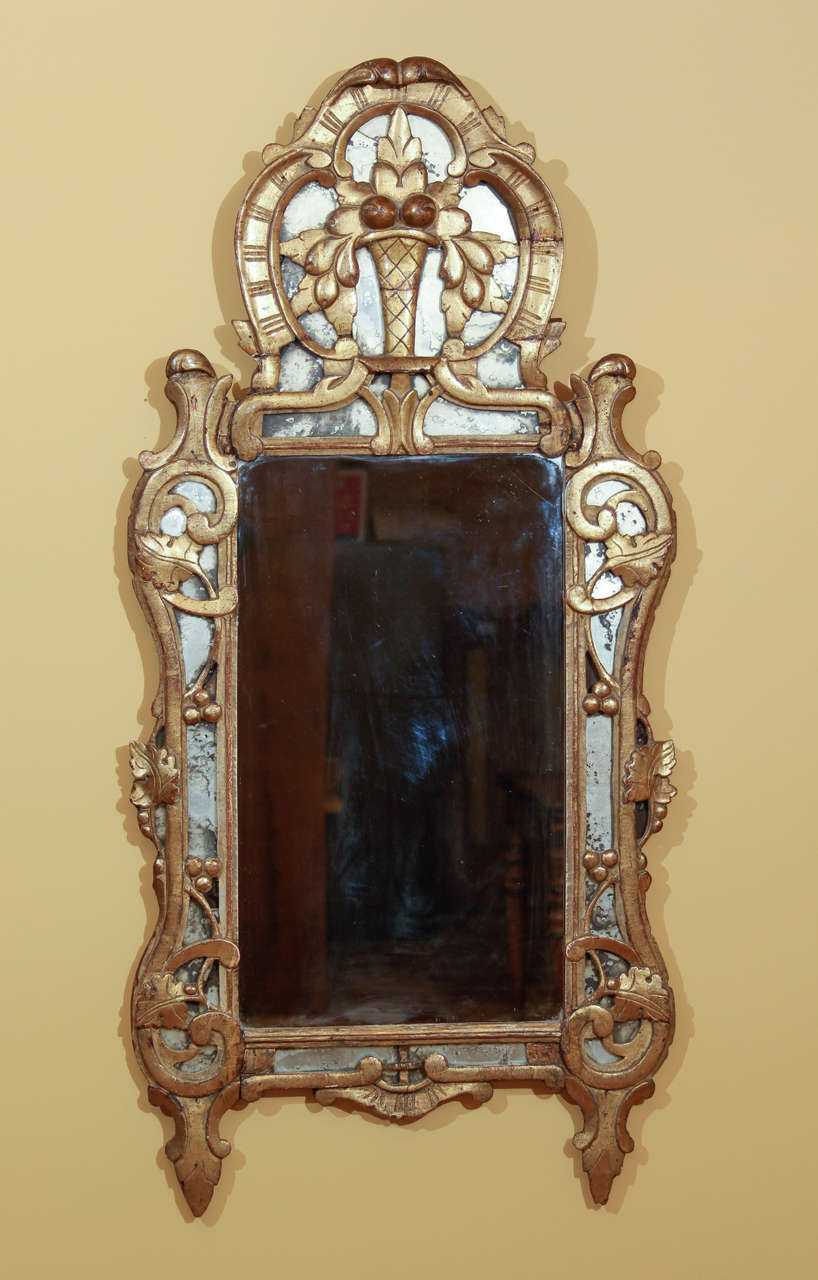 18th century Italian gilt mirror.  This is a fine Italian gilt cushion mirror.  A cushion mirror has the glass underneath the outer frame with gilt work directly on top. The gilt work consists of grape leaves and grapes indicating 