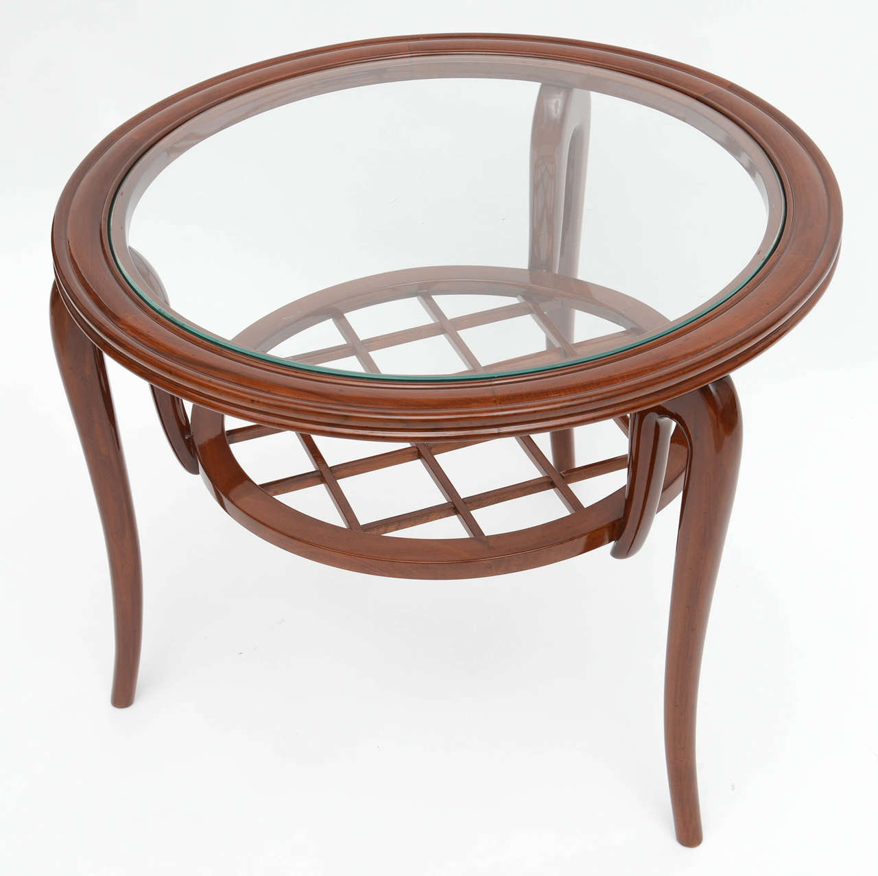 The circular top with inset glass with curved sculptural legs above a second tier with basket weave pattern.
Literature: illustrated in repertorio del design italiano- giuliani gramigna.