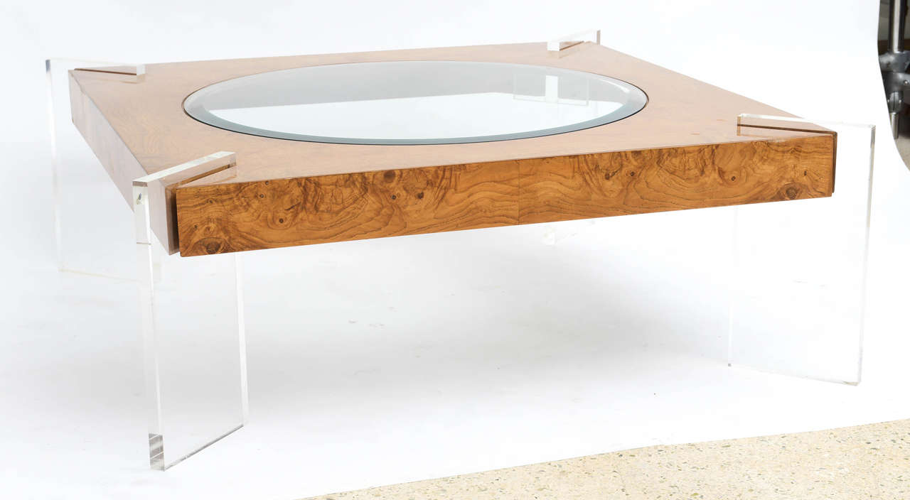 The thick Lucite canted legs piercing the burled walnut top with round inset glass
Kagan label to underside.