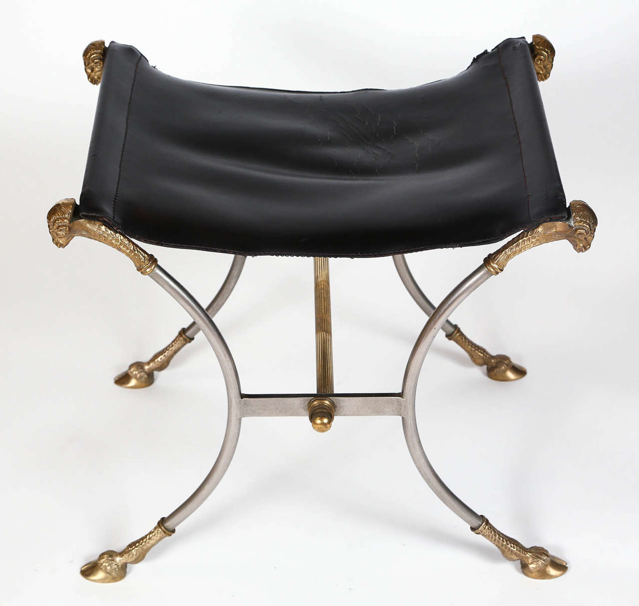Pair of vintage Italian steel neoclassical stool in the style of Maison Jansen. Features black leather seat with brass ram's head and hoof detailing. Two available. Sold separately.