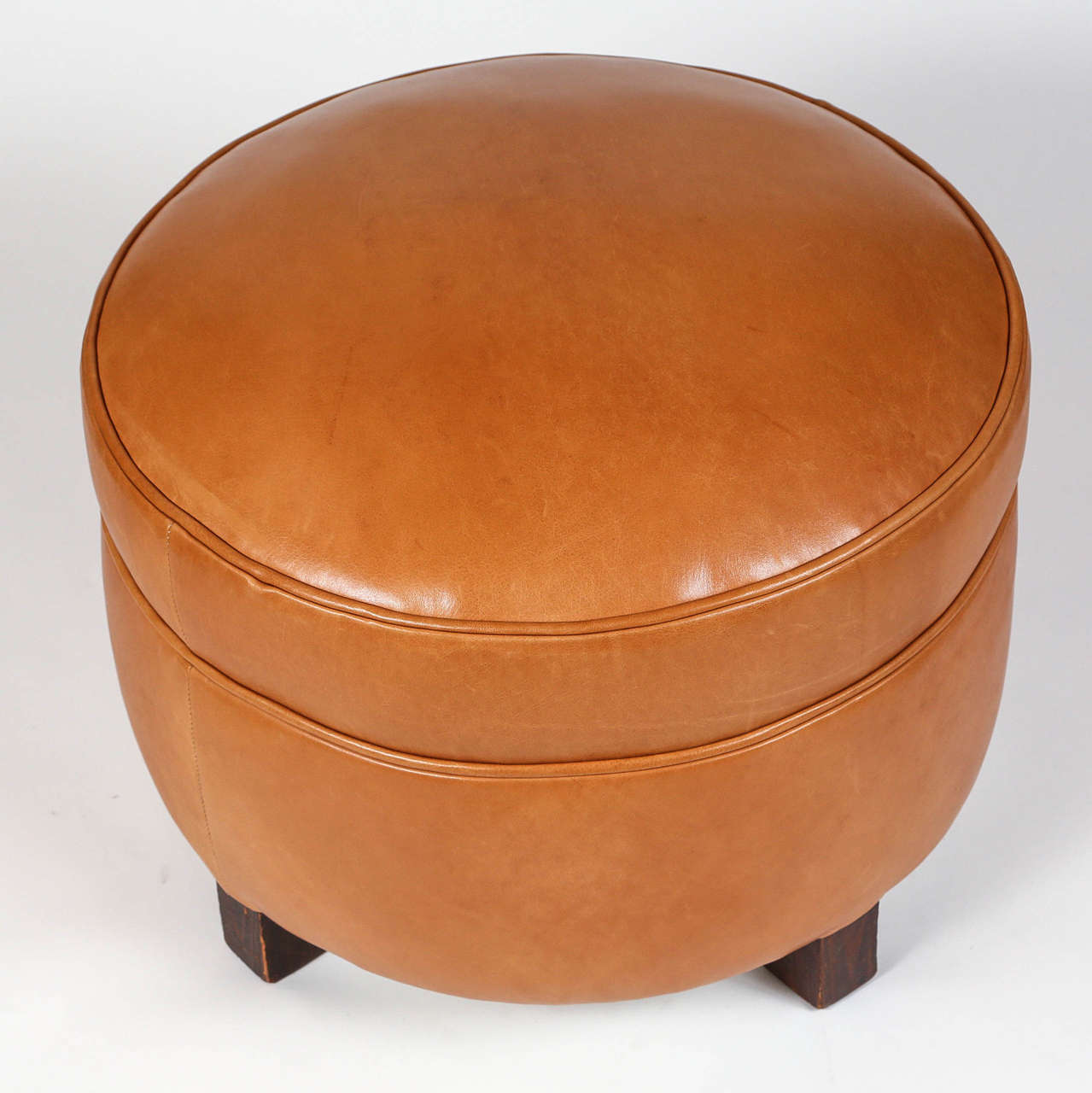 Vintage ottoman, newly upholstered in tan leather with distressed wood legs