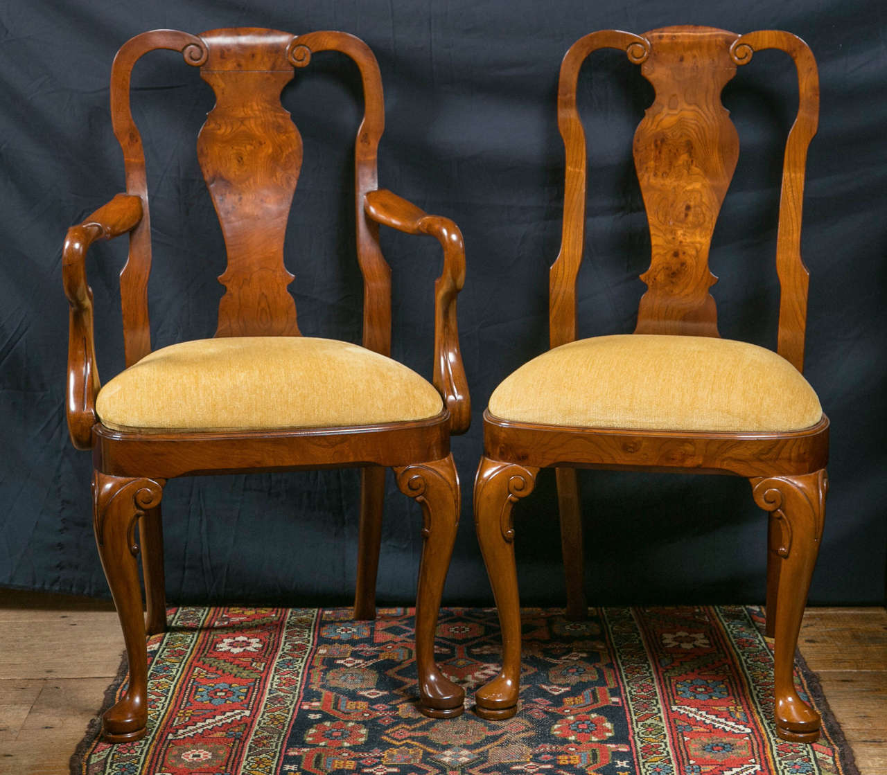 A set of ten, two arm chairs and eight side chairs; this set of walnut and walnut burl Queen Anne style dining chairs have curved wood splats that accept the curvature of the spine perfectly. Soft lines and a warm color give these chairs an