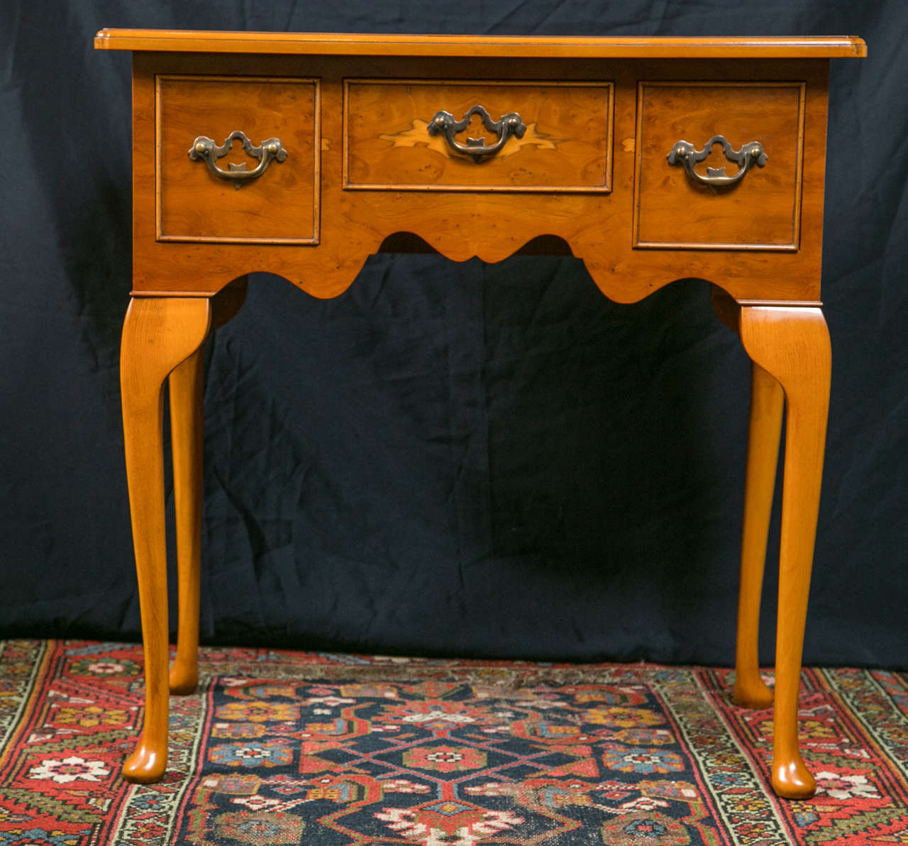 Custom-made for us by a small cabinet shop in England, this little lowboy in distinctive yew wood is proportioned squarely at 27” x 27” yet it reads more rectangular because the curved cabriole legs don’t take up the visual space of the drawers. In