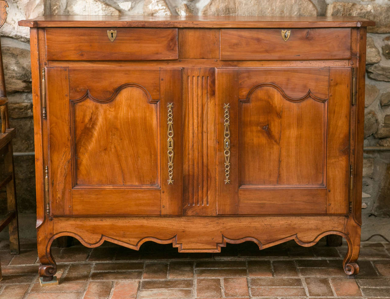 Two drawers over two shaped and recessed panel doors are the traditional arrangement for buffets and this one doesn’t disappoint. Even more delightful is the fact that the scalloped apron and scrolled feet have survived.