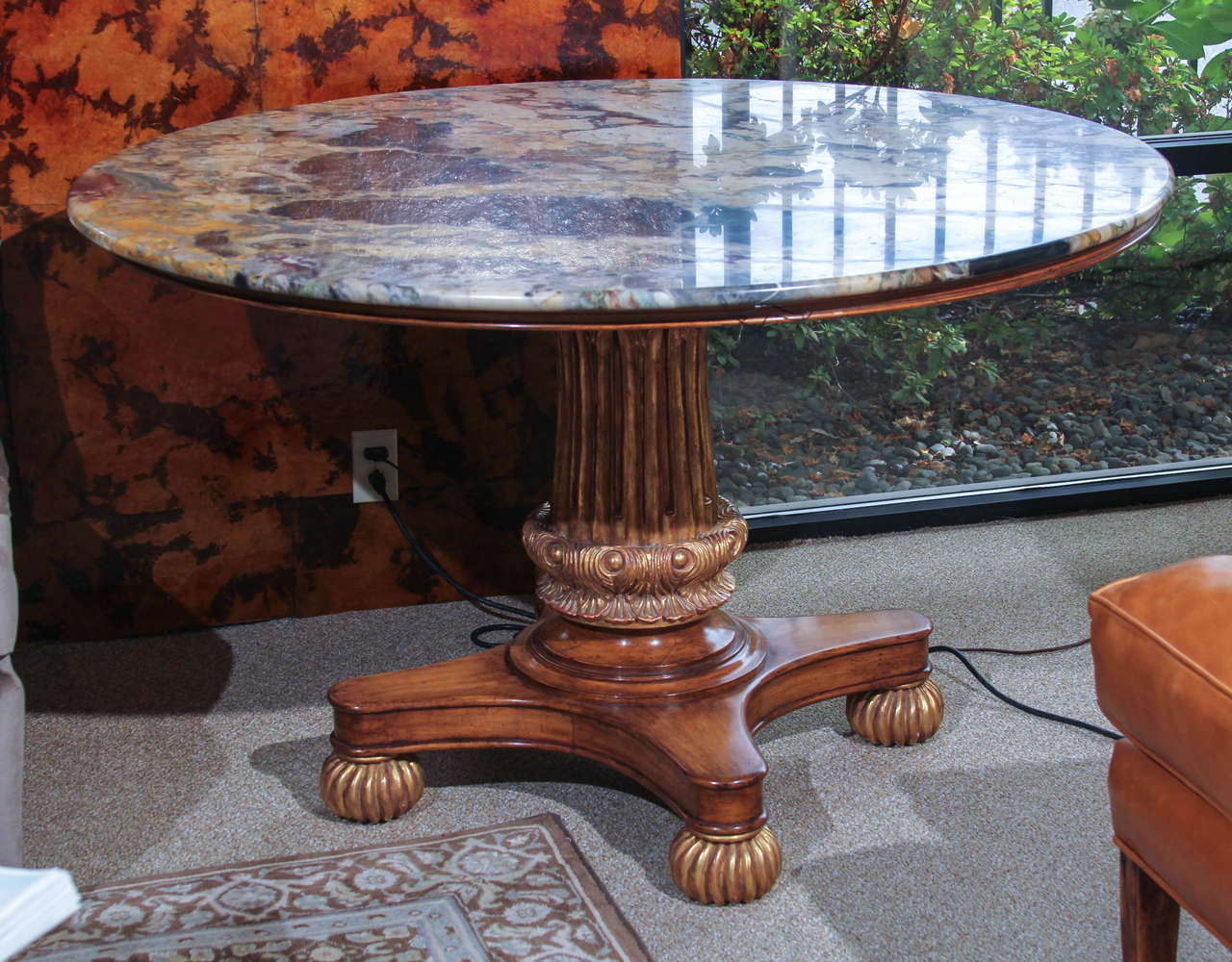 A magnificent vintage reproduction Regency style center table with a Breche Vendome marble top and carved and partially gilt base on bun feet. The marble has a very pleasing low luster sheen so has a sense of age not normally found in reproduction