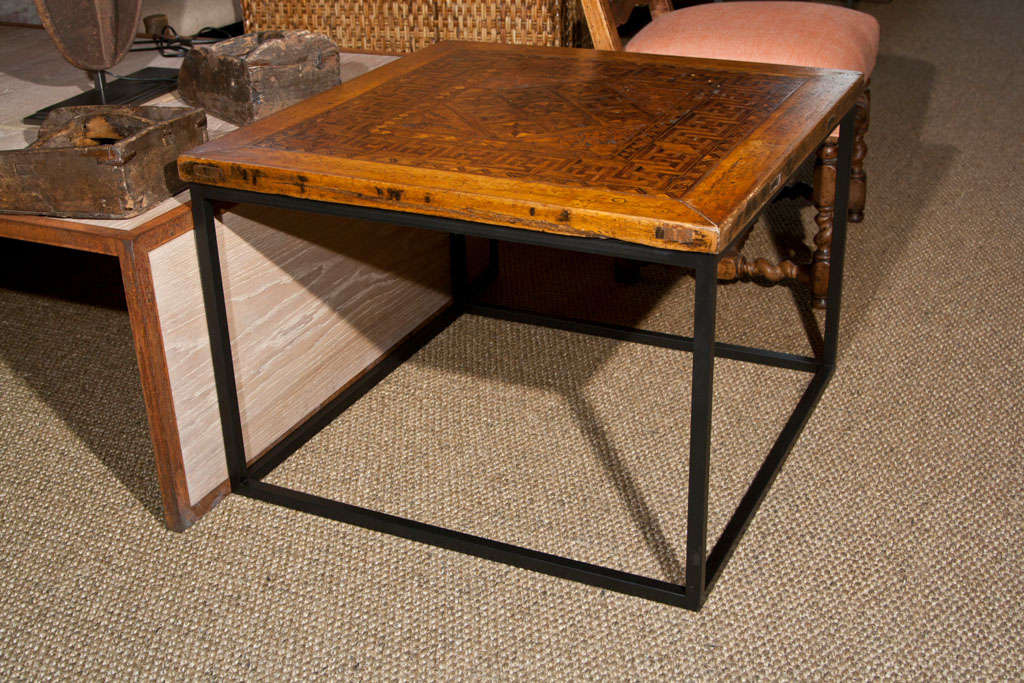 Iron side table with top made from an antique Mongolian wood inlay floor tile.