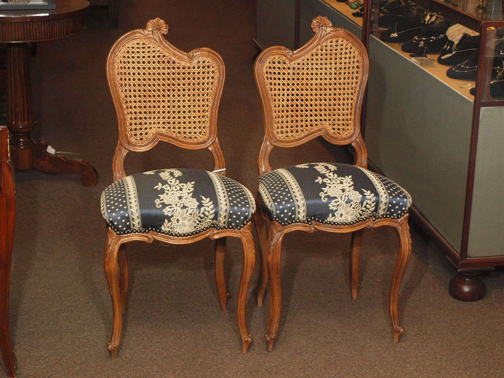 Pair of charming side chairs with undulating caned backs. carved cabriolet legs ending in scroll feet with a Damask upholstery.