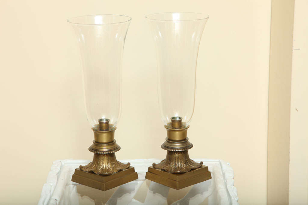 Pair of clear glass single-light hurricane vase table lamps.