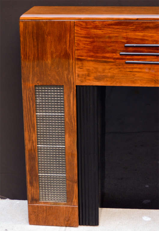Art Deco decorative fireplace mantel in mahogany wood with banded and fluted details in black lacquer, and with original textured and ribbed illuminated glass insets.  Inside of fireplace is in black lacquer with fluted front design.  Inside of