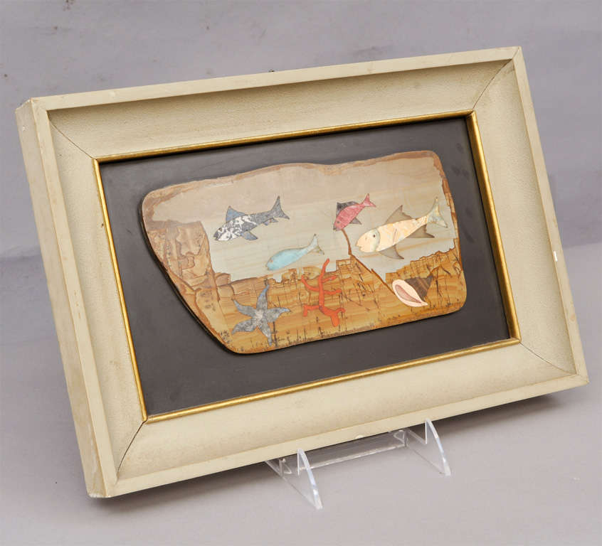 Framed pietra dura piece depicting fish, starfish and coral against slate, in painted wooden frame; signed: Leopoldo Menegatti.