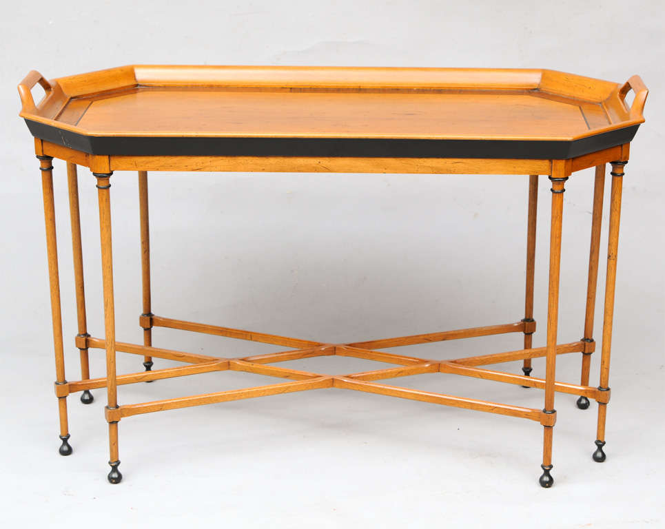 Tray table, having eight sided tray with handles, beautifully inlaid with stringing, raised on eight turned legs with ebonized accents, joined by double-x stretcher. Marked "Tomlinson."