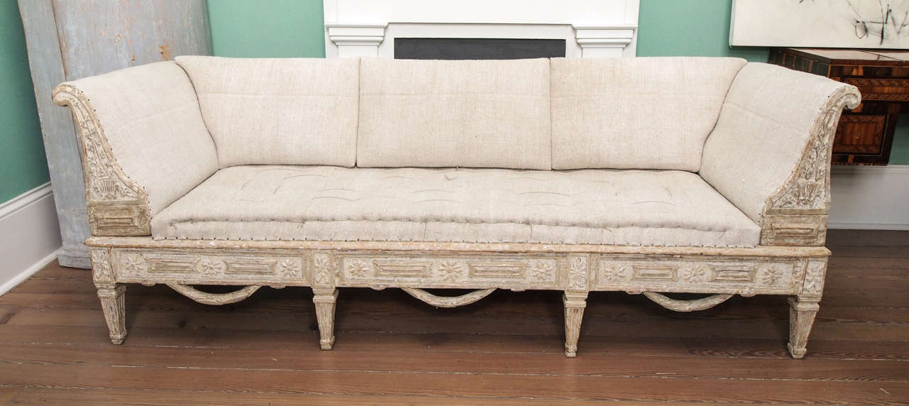 Painted Swedish sofa with elaborate carving and swags.