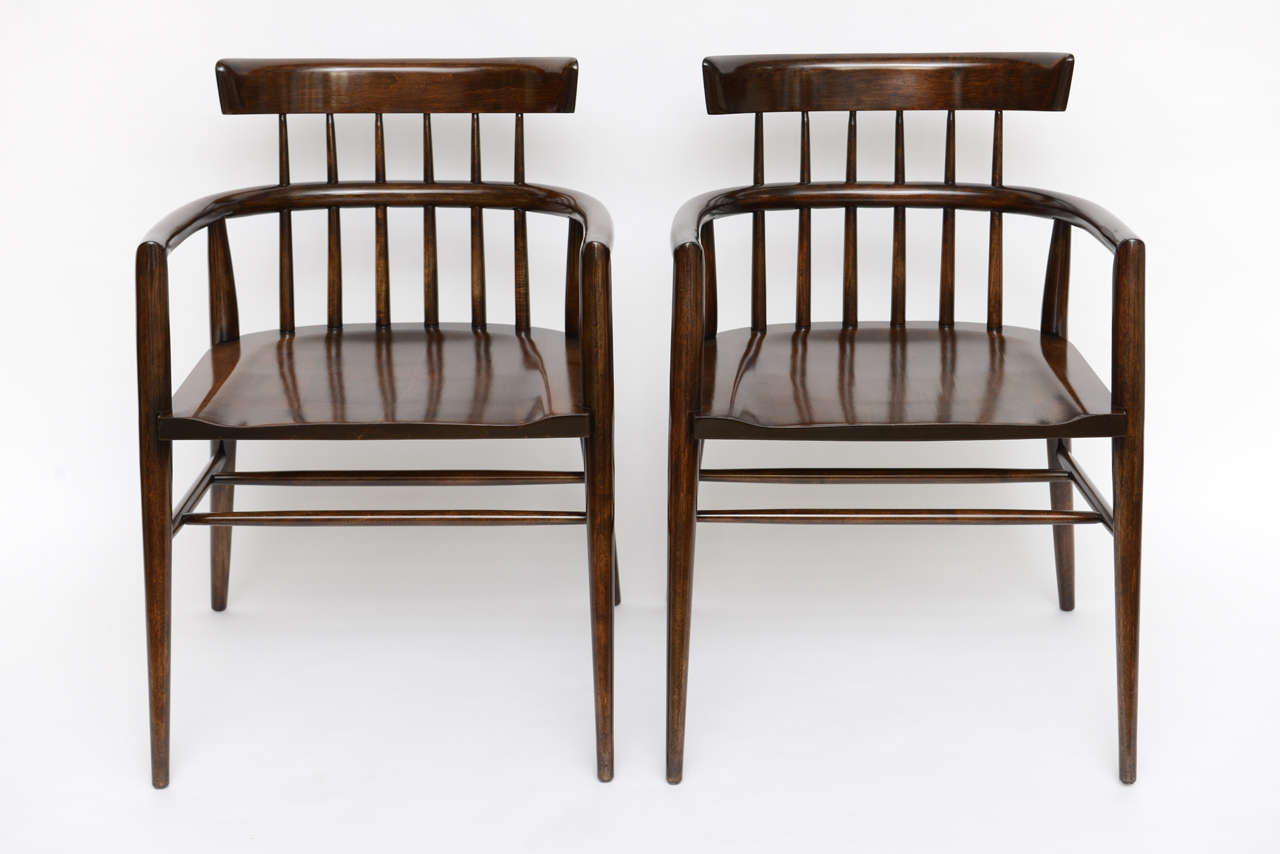 Handsome pair of Paul McCobb captain's chairs in walnut gloss finish.