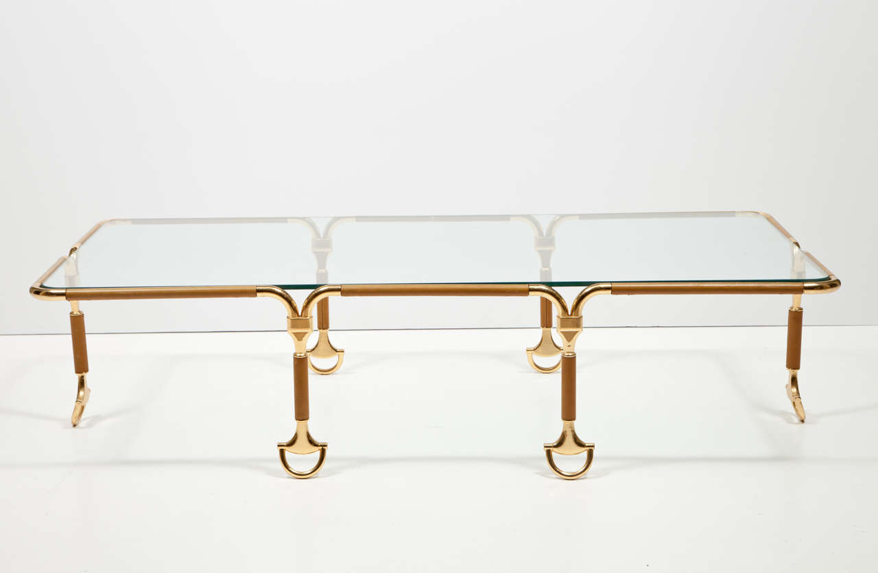 A rare Gucci Mid-Century Italian rectangular cocktail or coffee table, the tubular frame covered in caramel colored leather supporting a removable glass top resting on six legs, positioned in the middle of the long and short sides with gold-plated