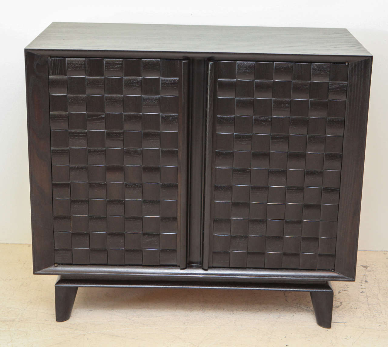 Two-door ebonized Paul Laszlo cabinet with basket weave carved front. Interior has shelves. Would make a great bar!