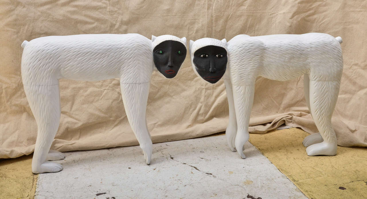 Pair chalk white painted monkey sculptures (baboons?) with dark gray faces & glass eyes. Great as low table to place a drink on next to a chair.