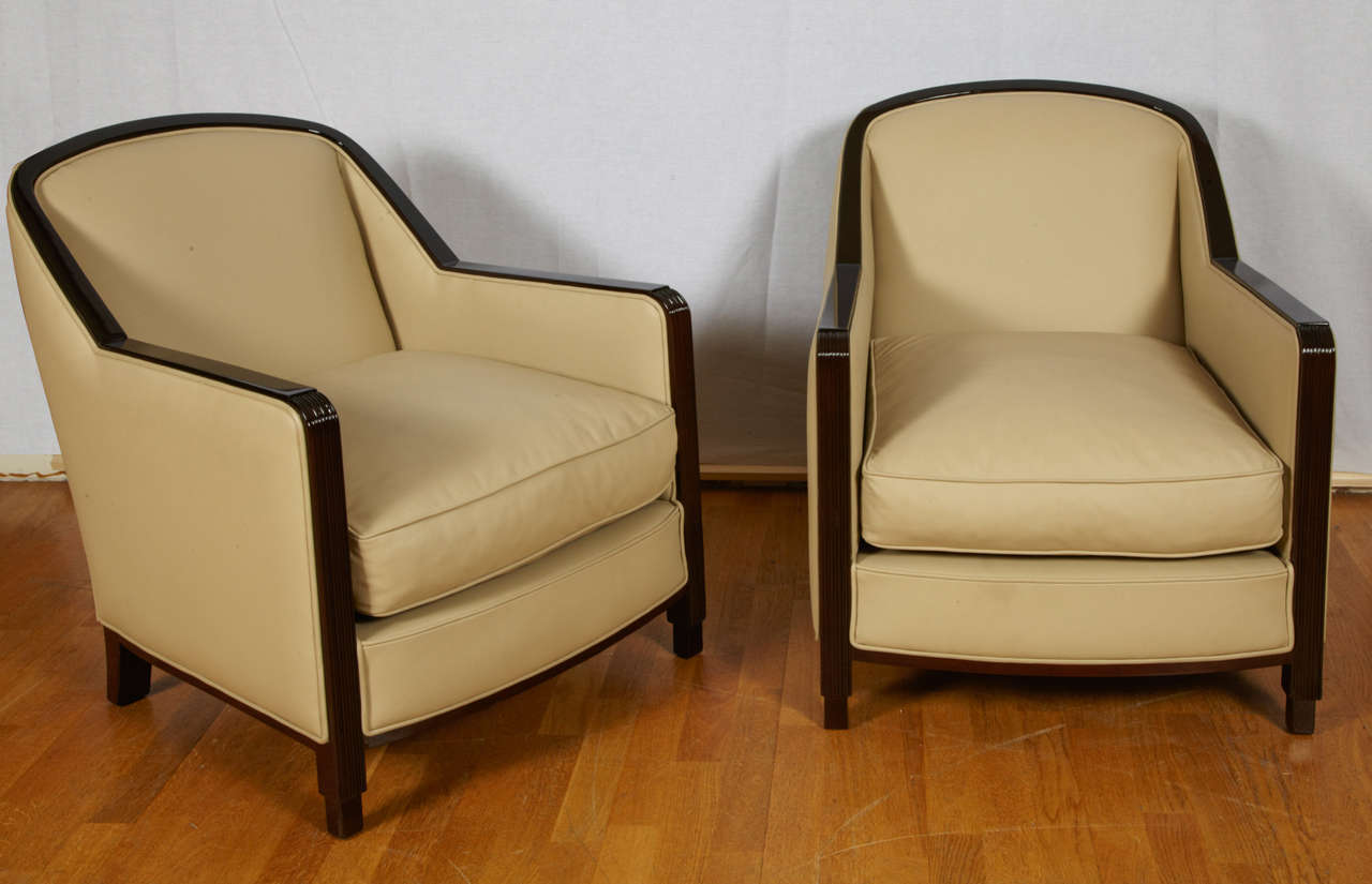 Paire de fauteuil d' époque Art-Déco circa 1935 en Hêtre teinté palissandre et cuir pleine fleur toutes faces. La descente des accoudoirs est cannelée et fini sur un décrochement, les pieds arrières sont de formes sabre.
Entièrement restauré