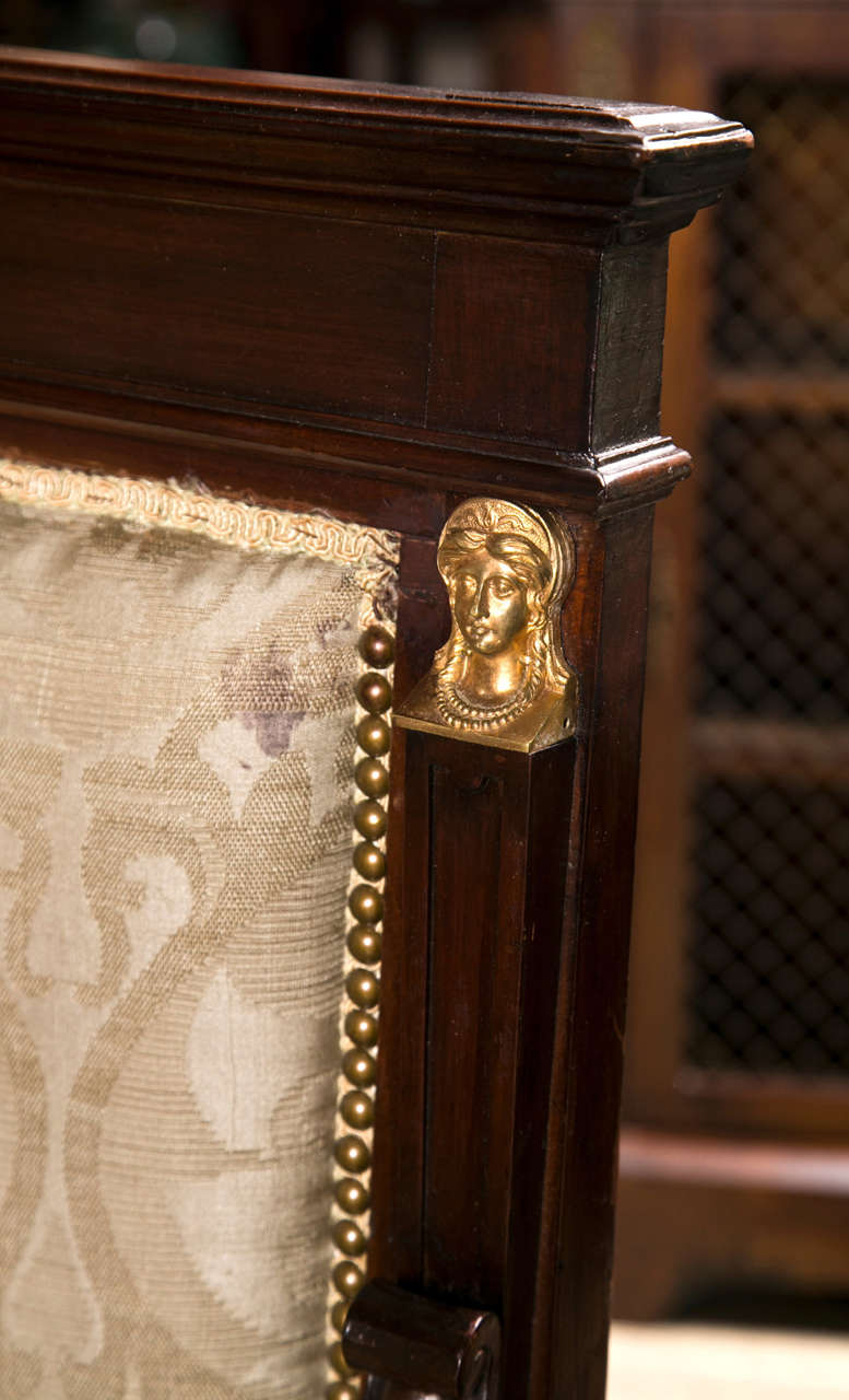 rectangular upholstered backs, upholstered seats.  padded arms. scrolled  arm ends, inward curving arm supports, mounted with gilt bronze female heads.
carved and molded legs.