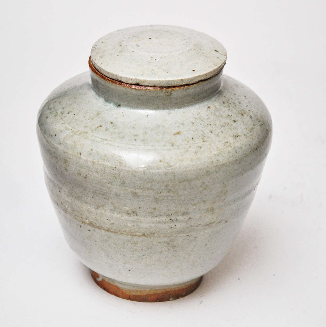 This is an apothecary jar with lid from the Ming Dynasty done in a gray celadon glaze.