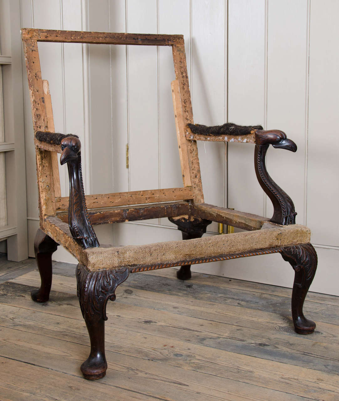 With upholstered rectangular back and seat within scroll arms each having a carved Eagle Head terminal on acanthus carved cabriole legs and pad feet