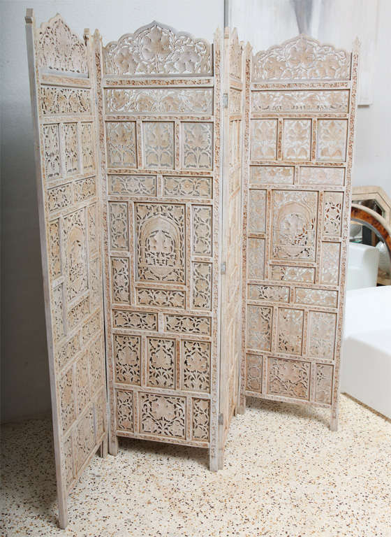 Delicate hand-carving lends an exotic air to this four panel teak screen, while the whitewashed color makes it beach-y keen.