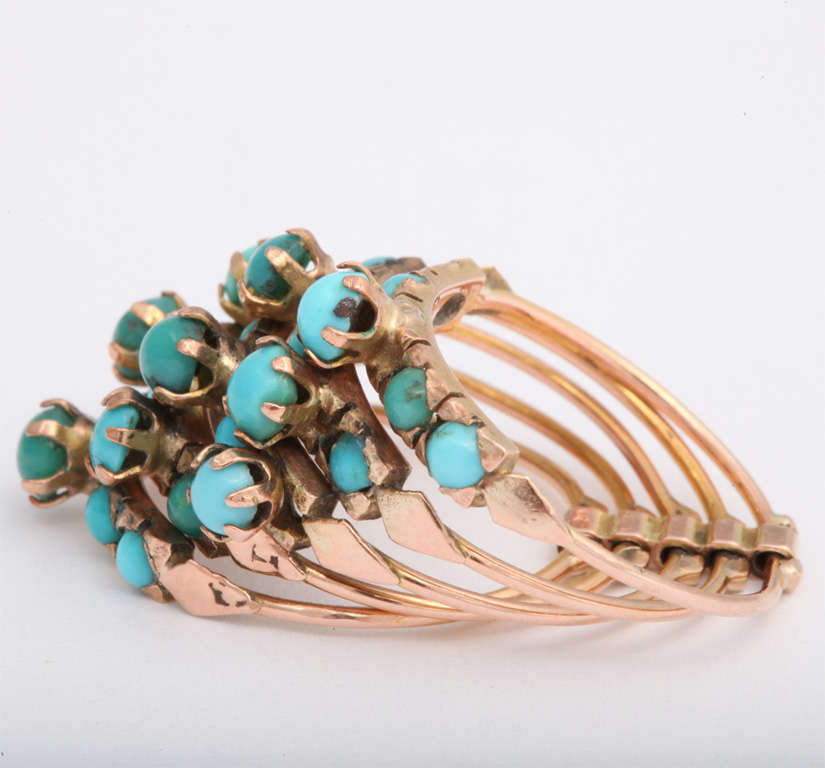 Many variations of different colored turquoise stones are prong set against the 14K rose gold of this vintage banded ring. Some of the turquoise is recessed and some are protruding and raised. The turquoise stones are very small in each prong. Also
