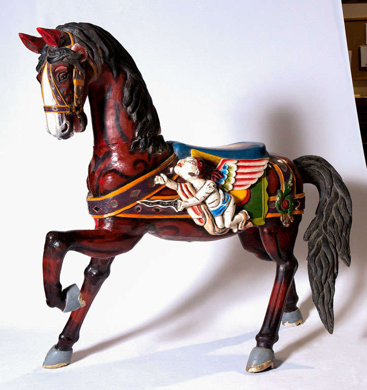 An impressive large wooden carousel horse with superb detail and coloring. Decorated with a winged figure on both sides. Nice seat. Bridal is mirrored with circle and diamond shapes. The tail is quite detailed. We were told it was Czechoslovakian. 