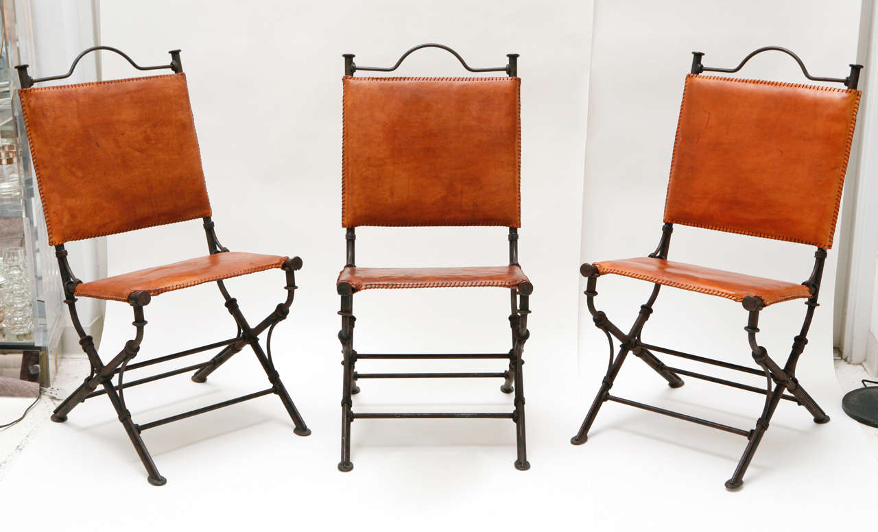 A handsome set of six chairs by Israeli-American artist Ilana Goor. The leather and iron are beautifully patinated and the chairs feature a handle detail at the top back and whipstitching around the edges of the leather back and seat pads.