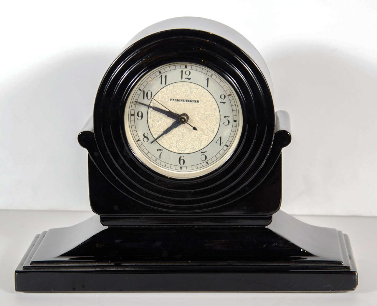 This gorgeous Black lacquer clock features original gilt and black  numerical face with stylized Art Deco numbers. The face of the clock is concentric Skyscraper style rings on a lyre pedestal platform design.Movement has been replaced with a new