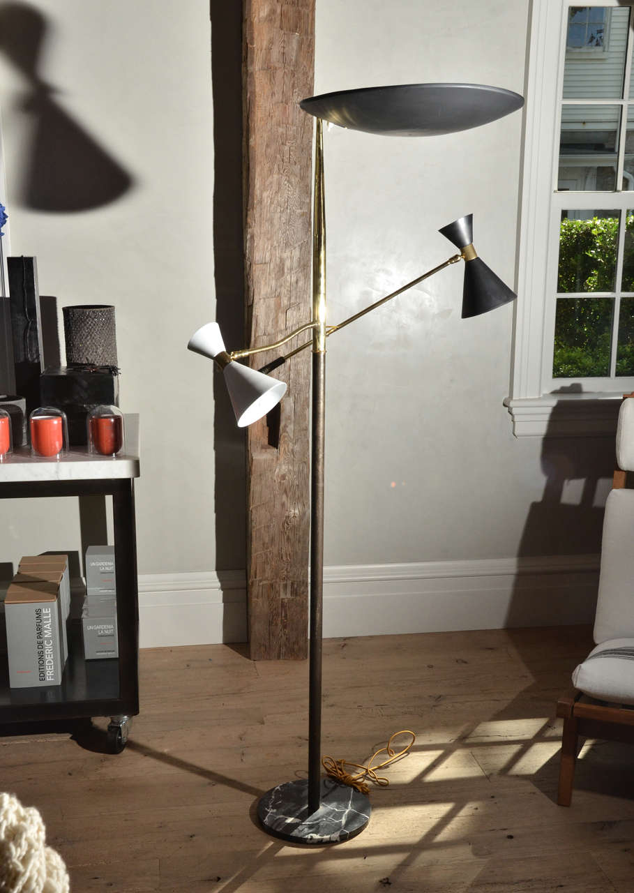 Beautiful designed 1950's  standing lamp by Stilnovo, Milan, Italy.  The lamp is equipped with two enameled shades, which are fully  adjustable,  one black and one white, and the top shade is black. The lamp frame is made out of solid brass and the