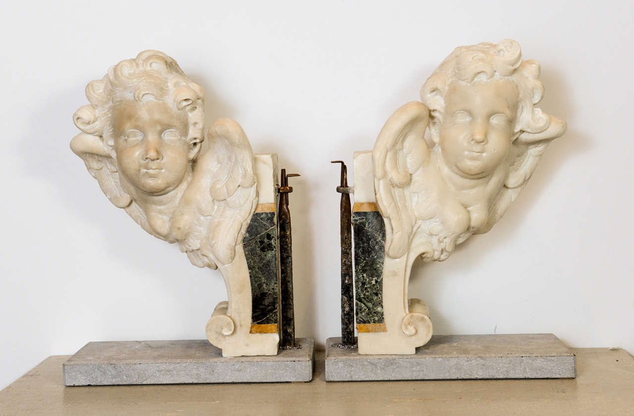 A pair of winged marble putto heads