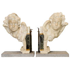 A pair of winged marble putto heads