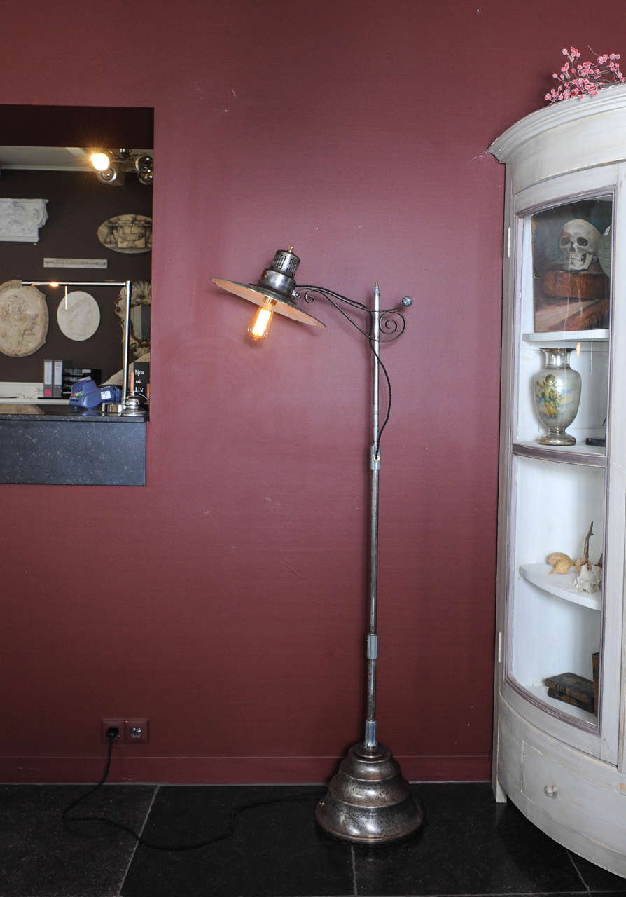 A General Electric New York converted sunlamp with green/white enamelled shade. Iron frame with brass details and brass makers mark. The old heavy converter in the foot now serving only as a weight. The top adjustable by squeezing the bracket.