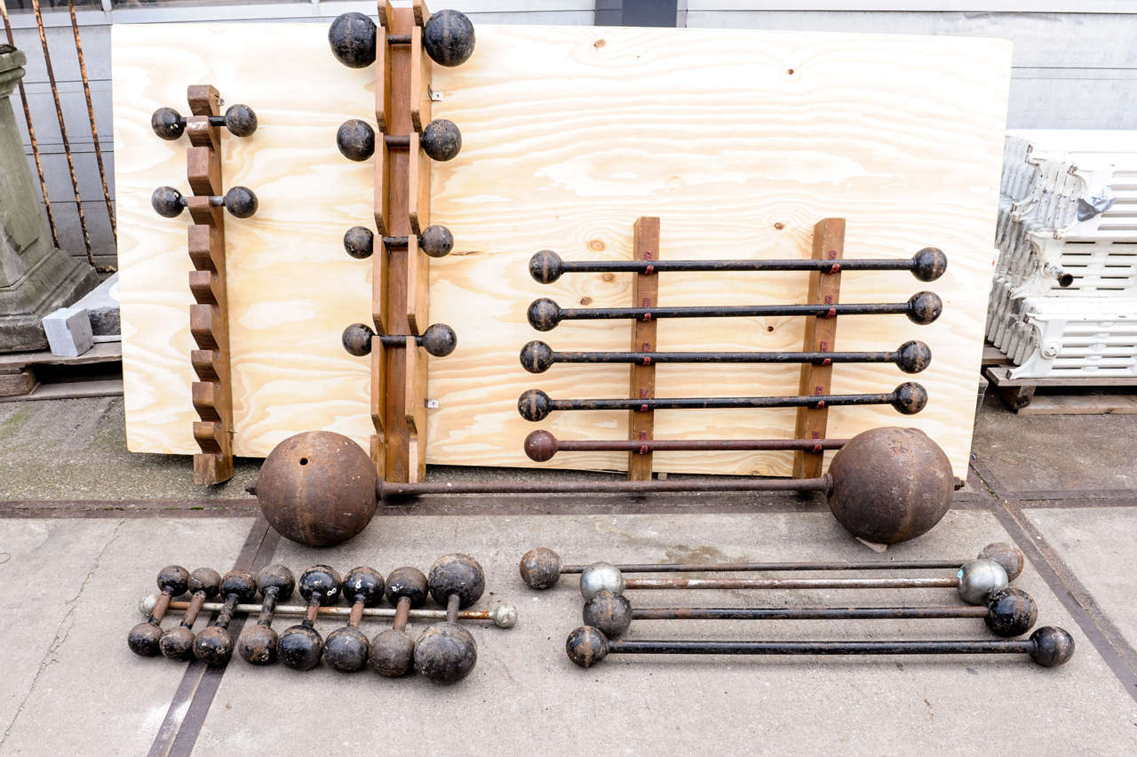 A set of 25 pieces antique dumbells, each one with a round cast iron ball, giving them  a nice turn of the century look. The big one consisting of hollow balls, one with an old crack. 
The lot makes a complete vintage gym interior.

The large one