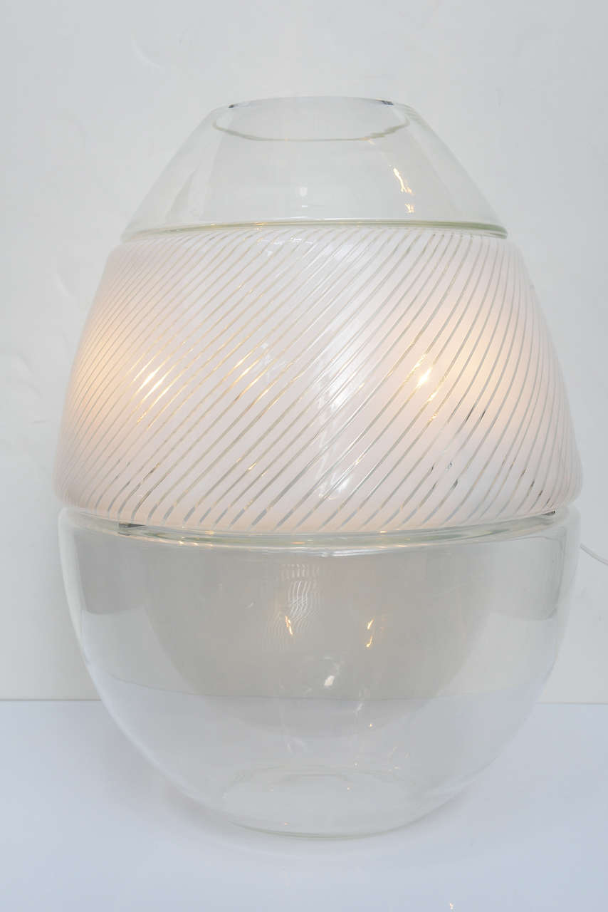 This exquisite Murano large Italian Hand-Crafted Blown Glass lamp is made in three pieces that all together composed the shape a stunning egg with clear and white striated. The middle section is containing a white iron ring with four sockets which